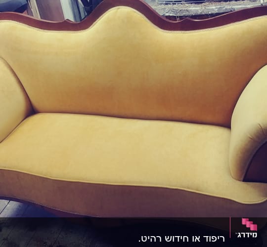 ספה מרופדת בבד צהוב עם מסגרת עץ כהה